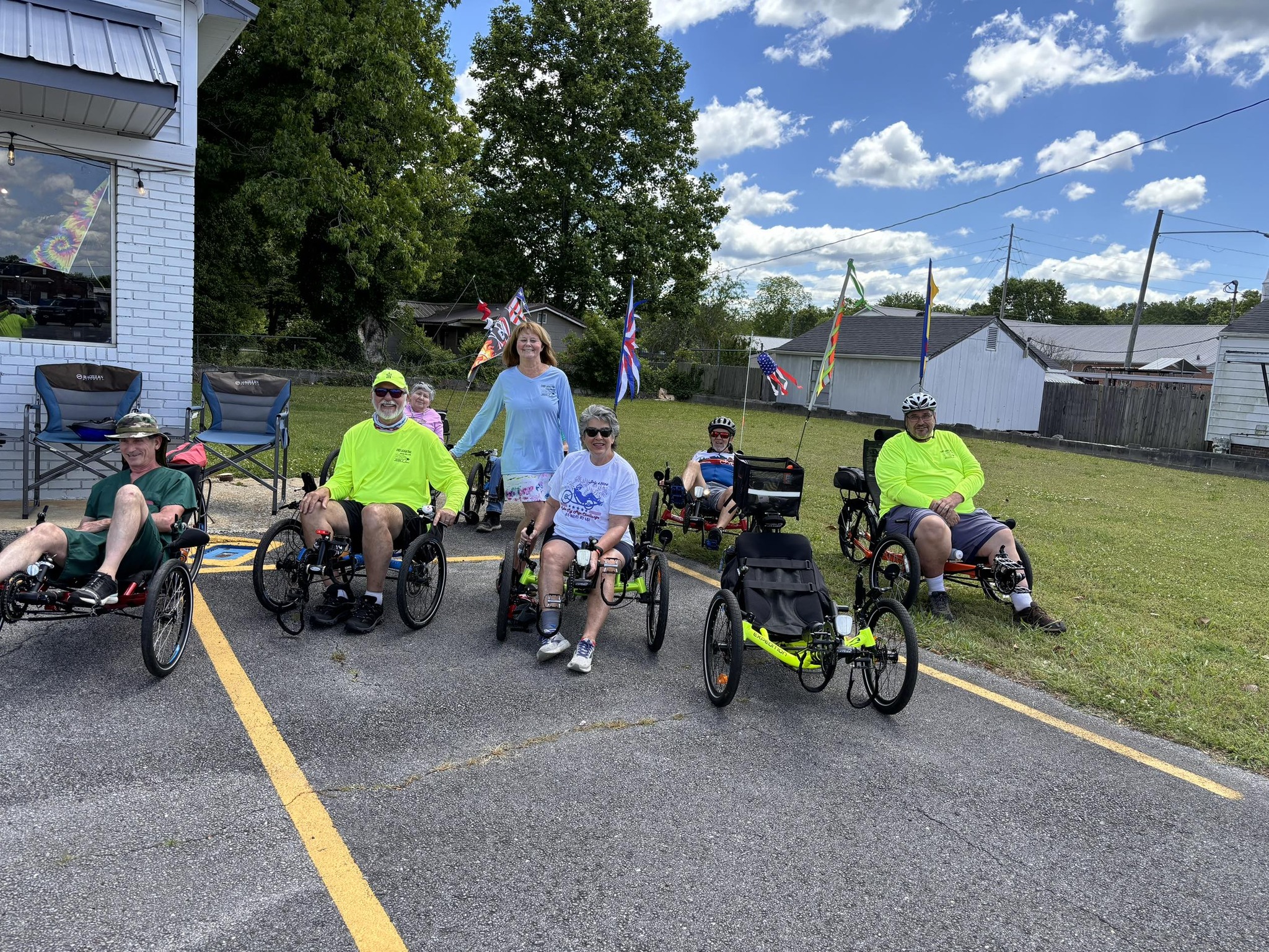 Smiling customers gathered with their recumbent trikes before a group ride