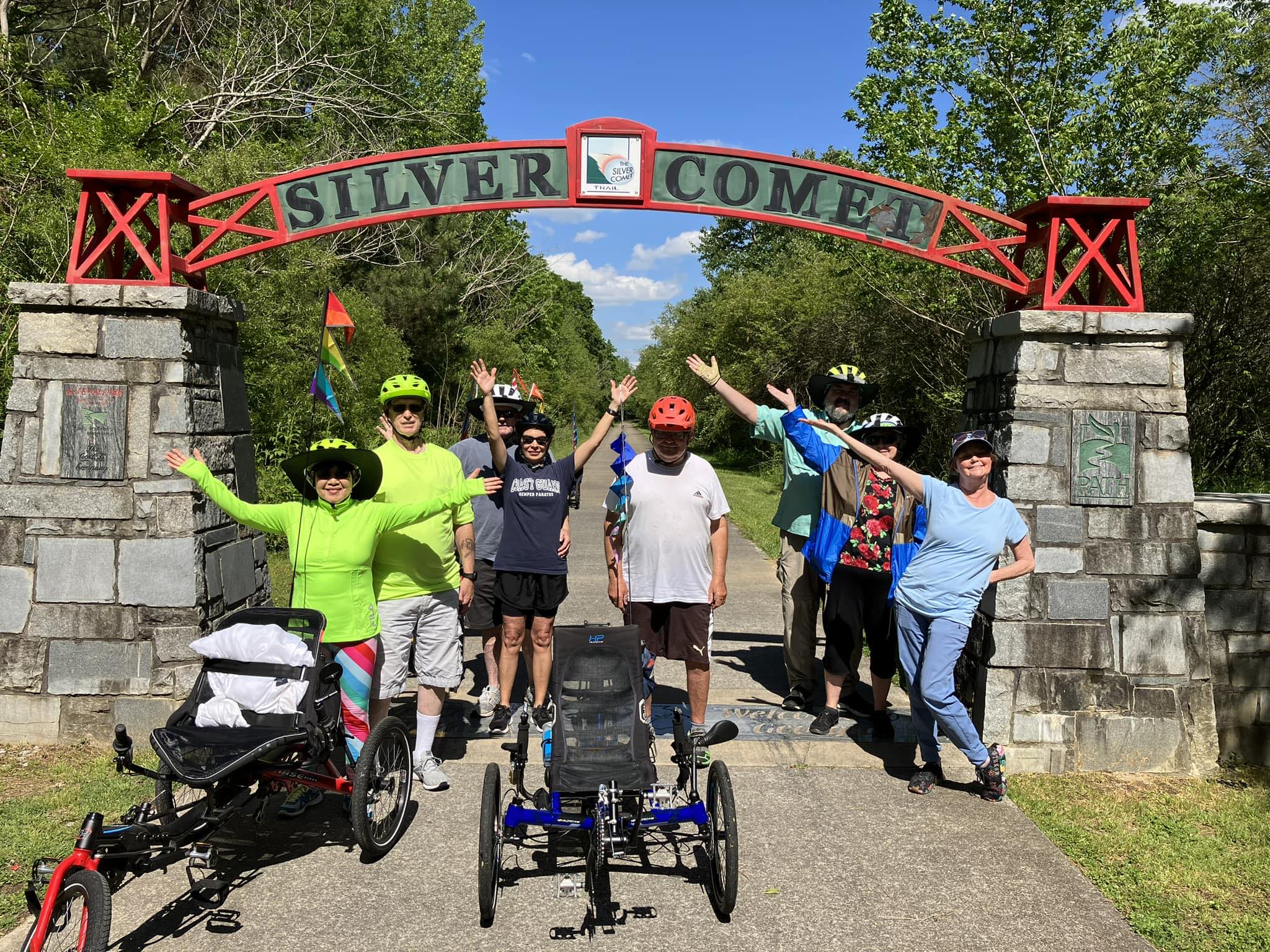 Group of recumbent trike riders celebrating at the Silver Comet Trail arch